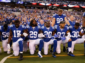 Members of the Indianapolis Colts stand and kneel for the national anthem before a game against the Cleveland Browns on Sept. 24.