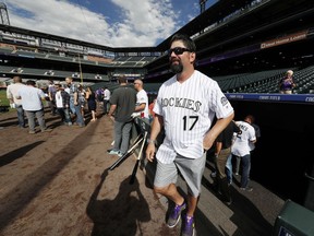 Retired Colorado Rockies first baseman Todd Helton (17) steps out of the dugout as members of the Rockies' 2007 Word Series team look on during batting practice before the Rockies host the San Diego Padres in a baseball game Friday, Sept. 15, 2017, in Denver. (AP Photo/David Zalubowski)