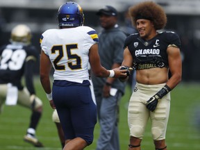 Northern Colorado running back Zachary Lindsay, greets his brother, Colorado running back Phillip Lindsay as the teams warm up before the first half of an NCAA college football Saturday, Sept. 16, 2017, in Boulder, Colo. (AP Photo/David Zalubowski)