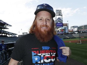 Los Angeles Dodgers third baseman Justin Turner wears a shirt to raise money for the Hurricane Maria relief fund as he warms up before a baseball game against the Colorado Rockies on Friday, Sept. 29, 2017, in Denver. (AP Photo/David Zalubowski)