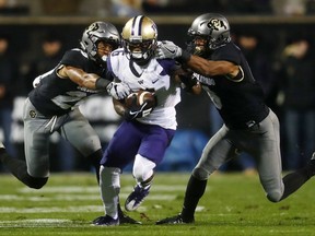 Washington wide receiver Chico McClatcher, center, is stopped by Colorado defensive backs Isaiah Oliver and Evan Worthington, right, during the first half of an NCAA college football game Saturday, Sept. 23, 2017, in Boulder, Colo. (AP Photo/David Zalubowski)