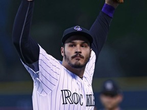 Colorado Rockies third baseman Nolan Arenado acknowledges the applause of the crowd as he emerges from the clubhouse after the Rockies earned the second wild card spot in the National League following Milwaukee's loss to St. Louis before the Rockies host the Los Angeles Dodgers in a baseball game Saturday, Sept. 30, 2017, in Denver. (AP Photo/David Zalubowski)