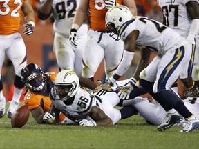 Los Angeles Chargers inside linebacker Korey Toomer (56) forces Denver Broncos running back Jamaal Charles (28) fumbles the football during the second half of an NFL football game, Monday, Sept. 11, 2017, in Denver. Los Angeles Chargers cornerback Casey Hayward, right, recovered the ball. (AP Photo/Jack Dempsey)