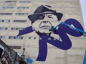 Montreal artist Kevin Ledo works on his nine-story high-portrait of the late Leonard Cohen, in Montreal on Thursday, June 15, 2017. A memorial tribute concert for Leonard Cohen will be held in Montreal on Nov. 6. THE CANADIAN PRESS/Paul Chiasson