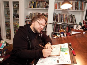 Guillermo del Toro, shown in this undated handout image, at work on one of his notebooks in the Comic Book Library at Bleak House. The Mexican-born film-maker and author opens up his world in the new Art Gallery of Ontario exhibit "Guillermo del Toro: At Home with Monsters." THE CANADIAN PRESS/HO-Insight Editions