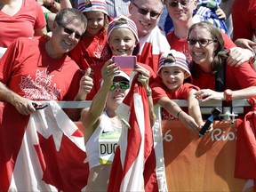 Krista Duchene of Canada takes a selfie with spectators after finishing the women's marathon at the 2016 Summer Olympics in Rio de Janeiro, Brazil, Sunday, Aug. 14, 2016. DuChene was only 12 kilometres into the 2013 world championship marathon in Moscow, when her legs gave way. THE CANADIAN PRESS/ AP/Robert F. Bukaty