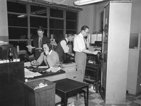 Photo editor Roger Varley, left to right, photo editor George Garlock, photo technician Fred Reynolds and chief of picture Jack Tracy work in the photo department in Toronto in this 1959/60 file photo. The Canadian Press, the national news service that was created during the First World War to bring home stories from the European front -- and went on to become the country's go-to, real-time source -- turned 100 Friday. But even dedicated news junkies might not know where to send a birthday card. Described by some scholars as a cornerstone of Canadian history, CP remains a mystery to many, a low-profile but central part of the news landscape. Its news stories, photos, videos and radio broadcasts, in both official languages, appear in almost every media outlet in the country, yet readers or listeners are often unaware of their source. THE CANADIAN PRESS