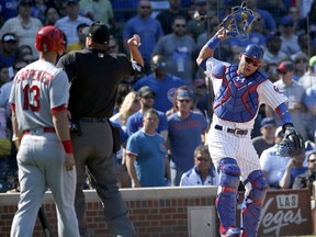 Chicago Cubs catcher Willson Contreras, right, slams his mask down as home plate umpire Jordan Baker tosses him out of the game while St. Louis Cardinals' Matt Carpenter watches during the fifth inning of a baseball game Friday, Sept. 15, 2017, in Chicago. (AP Photo/Charles Rex Arbogast)