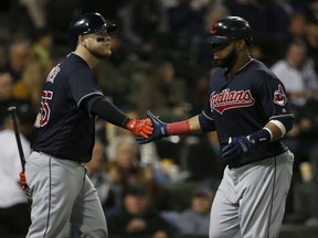 Cleveland Indians' Carlos Santana, right, celebrates with Roberto Perez after scoring on a sacrifice fly hit by Tyler Naquin during the fourth inning of a baseball game against the Chicago White Sox, Wednesday, Sept. 6, 2017, in Chicago. (AP Photo/Nam Y. Huh)