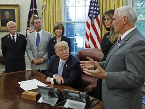 President Donald Trump looks at Vice President Mike Pence as he speaks about Harvey in the Oval Office of the White House with Commissioner David Hudson, National Commander, Salvation Army USA, left, Kevin Ezell, President of Southern Baptist Disaster Relief, American Red Cross CEO Gail McGovern, and first lady Melania Trump Friday, Sept. 1, 2017, in Washington. (AP Photo/Alex Brandon)