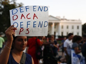 A woman holds up a sign that reads "Defend DACA Defend TPS" during a rally supporting Deferred Action for Childhood Arrivals, or DACA, outside the White House in Washington, Monday, Sept. 4, 2017. TPS stands for "Temporary Protected Status." A plan President Donald Trump is expected to announce Tuesday for young immigrants brought to the country illegally as children was embraced by some top Republicans on Monday and denounced by others as the beginning of a "civil war" within the party. (AP Photo/Carolyn Kaster)