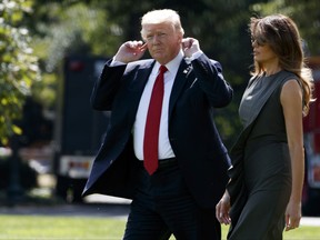 President Donald Trump listens to questions shouted by reporters as he walks with first lady Melania Trump to board Marine One on the South Lawn of the White House, Friday, Sept. 8, 2017, in Washington. (AP Photo/Evan Vucci)