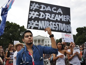 Carlos Esteban, 31, of Woodbridge, Va., a nursing student and recipient of Deferred Action for Childhood Arrivals, known as DACA, rallies with others in support of DACA outside of the White House, in Washington, Tuesday, Sept. 5, 2017. President Donald Trump began dismantling the government program protecting hundreds of thousands of young immigrants who were brought into the country illegally as children. (AP Photo/Jacquelyn Martin)
