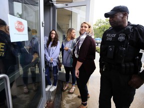 Survivors of sexual assault Faith Ferber, center and Sage Carson, second from right, together with a supporter of survivors Bailey Bystry, third from right, are met at the door of the Department of Education by security personnel as they try to hand signed petitions at the Department of Education that support the Dear Colleague Letter, just 24 hours before Betsy DeVos is expected to announce her Title IX plan in Washington, Wednesday, Sept. 6, 2017.