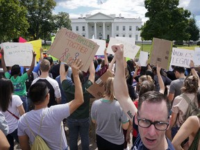 Malcolm McCluskey, right, pumps his fist in the air as he joins in a chant with supporters of Deferred Action for Childhood Arrival program (DACA) during a demonstration on Pennsylvania Avenue in front of the White House in Washington, Saturday, Sept. 9, 2017. President Donald Trump ordered and end of protections for young immigrants who were brought into the country illegally as children, but gave Congress six months to act on it. (AP Photo/Pablo Martinez Monsivais)