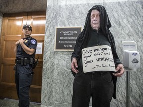 Costumed as the grim reaper, a protestor opposed to the Republican health care bill waits prior to a hearing by the Senate Finance Committee on the Graham-Cassidy health care repeal, on Capitol Hill in Washington, Monday, Sept. 25, 2017. (AP Photo/J. Scott Applewhite)
