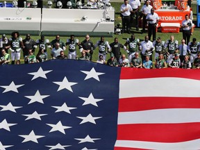 New York Jets players lock arms during the national anthem before a game against the Miami Dolphins on Sept. 24.