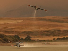 Water bombers pick up water at the Waterton Dam, north of Waterton Lakes National Park, Alta. on Tuesday, September 12, 2017, adding to the fight against a large fire burning in the park. THE CANADIAN PRESS/David Rossiter