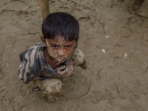 A Rohingya Muslim boy, who crossed over from Myanmar into Bangladesh, waits to receive aid during a distribution near Balukhali refugee camp, Bangladesh, Thursday, Sept. 28, 2017. More than 400,000 Rohingya Muslims have fled to Bangladesh since Aug. 25, when deadly attacks by a Rohingya insurgent group on police posts prompted Myanmar's military to launch "clearance operations" in Rakhine state. (AP Photo/Dar Yasin)