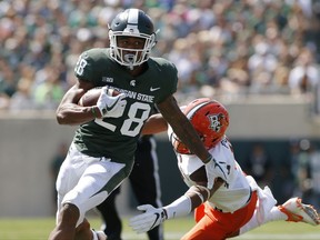 Michigan State running back Madre London, left, gets past Bowling Green's Armani Posey for a first down during the second quarter of an NCAA college football game, Saturday, Sept. 2, 2017, in East Lansing, Mich. (AP Photo/Al Goldis)