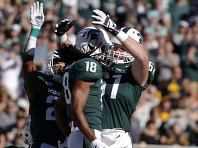 Michigan State's Felton Davis III, center, Cole Chewins, right, and Darryl Stewart, left, celebrate Davis' touchdown reception against Iowa during the first half of an NCAA college football game, Saturday, Sept. 30, 2017, in East Lansing, Mich. (AP Photo/Al Goldis)