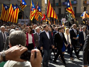 The President of the government of Catalonia, Carles Puigdemont, center, walks with a number of mayors under investigation, outside the Generalitat Palace, to protest against the ruling of the constitutional court ahead of a planned independence referendum in the Catalonia region, in Barcelona, Spain, Saturday, Sept. 16, 2017. (AP Photo/Emilio Morenatti)