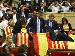 Members of the Catalan Popular Party display Spanish flags just before abandoning the session ahead of the voting during a plenary session at the Parliament of Catalonia in Barcelona, Spain, Wednesday, Sept. 6, 2017. Catalan lawmakers are voting on a bill that will allow regional authorities to officially call an Oct. 1 referendum on a split from Spain, making concrete a years-long defiance of central authorities, who see the vote as illegal. (AP Photo/Manu Fernandez)