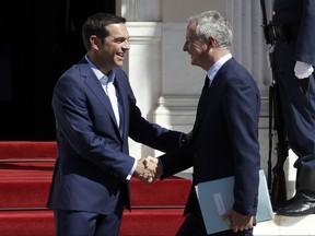 Greek Prime Minister Alexis Tsipras, left, welcomes French Economy Minister Bruno Le Maire at Maximos Mansion in Athens, Thursday, Sept. 7, 2017. Macron arrives in Greece on a two-day official visit expected to focus on Greece's financial crisis. (AP Photo/Thanassis Stavrakis)