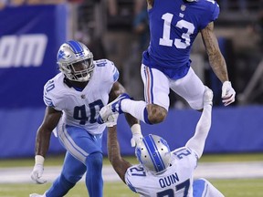 New York Giants wide receiver Odell Beckham (13) leaps over Detroit Lions' Glover Quin (27) as Jarrad Davis (40) watches during the first half of an NFL football game, Monday, Sept. 18, 2017, in East Rutherford, N.J. (AP Photo/Bill Kostroun)