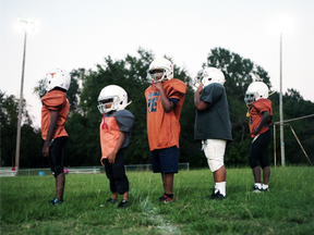 In this Oct. 20, 2016 file photo, young football players wait in line to try out their tackle techniques during practice in Marshall, Tex.