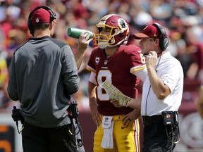 Washington Redskins head coach Jay Gruden, right, speaks with quarterback Kirk Cousins (8) during a break in play in the first half of an NFL football game against the Philadelphia Eagles, Sunday, Sept. 10, 2017, in Landover, Md. (AP Photo/Mark Tenally)