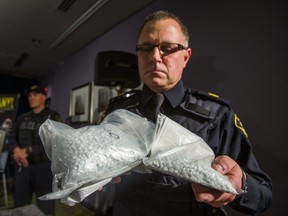 OPP Sgt. Peter Leon holds seized bags of fentanyl on display at a press conference at a hotel in Vaughan, Ont. on Thursday February 23, 2017, after a after a multi-jurisdiction investigation.