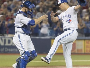 Toronto Blue Jays pitcher Roberto Osuna and catcher Russell Martin celebrate after defeating the Kansas City Royals in their American League MLB baseball game in Toronto on Tuesday, September 19, 2017. THE CANADIAN PRESS/Fred Thornhill