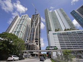 A high-rise building under construction is shown next to high-rise condominium buildings, Thursday, Sept. 7, 2017, in downtown Miami. As Hurricane Irma threatens to pound Miami with winds of mind-boggling power, a heavyweight hazard looms over the city's skyline: two dozen enormous construction cranes. Because those cranes weren't designed to withstand a storm of Irma's ferocity, city officials are telling people who live in the shadows of the giant lifting devices to leave. (AP Photo/Alan Diaz)