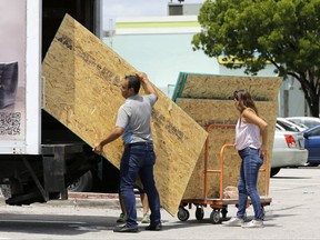 Residents load sheets of strand board on a truck as they prepare for Hurricane Irma, Tuesday, Sept. 5, 2017, in Hialeah, Fla. Hurricane Irma grew into a dangerous Category 5 storm, the most powerful seen in the Atlantic in over a decade, and roared toward islands in the northeast Caribbean Tuesday on a path that could eventually take it to the United States. (AP Photo/Alan Diaz)