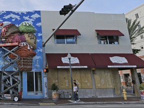 A worker secures the ice cream cone sign in preparation for Hurricane Irma, Thursday, Sept. 7, 2017, in the Little Havana area in Miami. South Florida officials are expanding evacuation orders as Hurricane Irma approaches, telling more than a half-million people to seek safety inland. (AP Photo/Alan Diaz)