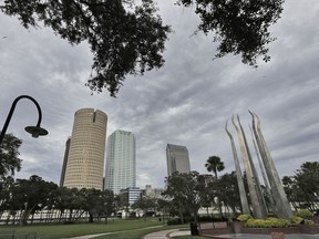 FILE- This Sept. 9, 2017, file photo, shows storm clouds associated with the outer bands of Hurricane Irma over the downtown skyline in Tampa, Fla. Study after study has shown that the Tampa region is among the world's most vulnerable when it comes to major storms. Yet, so far it has failed to take some key precautions, such as burying power lines, ending the practice of filling and building in wetlands and putting brakes on residential development. (AP Photo/Chris O'Meara, File)