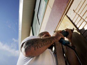 Shay Rymer, a native of Houston, Texas, helps boards up the motel he's living in ahead of Hurricane Irma in Daytona Beach, Fla., Friday, Sept. 8, 2017. Rymer has family recovering from Hurricane Harvey's flooding in Houston as he now prepares to take shelter and ride out Hurricane Irma in the motel. Coastal residents around South Florida have been ordered to evacuate as the killer storm closes in on the peninsula for what could be a catastrophic blow this weekend. (AP Photo/David Goldman)