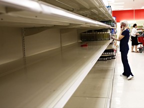 Kailey Coventry walks past empty shelves of water at Target in Gainesville, Fla., on Wednesday, Sept. 5, 2017. "Hurricanes are always super last minute but I just want to make sure I'm prepared," said Coventry. Irma roared into the Caribbean with record force early Wednesday, its 185-mph winds shaking homes and flooding buildings on a chain of small islands along a path toward Puerto Rico, Cuba and Hispaniola and a possible direct hit on densely populated South Florida.   (Andrea Cornejo/The Gainesville Sun via AP)