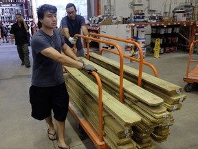 Hanz Paez, left, and Cirous Amiri, right buy wood at a Home Depot in South Miami Dade to secure their property in anticipation of Hurricane Irma early Friday, Sept. 8, 2017 in Miami, Fla. The National Hurricane Center says Hurricane Irma weakened a bit more but remains a powerful threat to Florida. (AP Photo/Gaston De Cardenas)