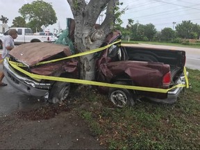 This photo provided by the Monroe County Sheriff's Office shows the wreckage of a truck wrapped around a tree near 98th Street and Highway 1 in Marathon, Fla., in the Florida Keys on Saturday, Sept. 9, 2017. Authorities say they are investigating whether Hurricane Irma's wind and rains contributed to the fatal crash. (Monroe County Sheriff's Office via AP)