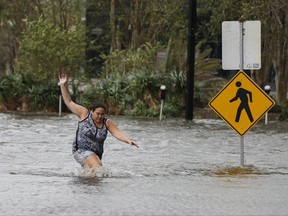 A woman wades through flood water from the St. Johns Rivers in the wake Hurricane Irma Monday, Sept. 11, 2017, in Jacksonville, Fla.. (AP Photo/John Bazemore)