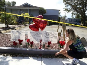 Janice Connelly of Hollywood, sets up a makeshift memorial in memory of the senior citizens who died in the heat at The Rehabilitation Center at Hollywood Hills, Fla. (Carline Jean /South Florida Sun-Sentinel via AP)