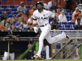 Miami Marlins' Dee Gordon runs home to score on a sacrifice fly by Justin Bour during the first inning of a baseball game against the Atlanta Braves, Saturday, Sept. 30, 2017, in Miami. (AP Photo/Lynne Sladky)
