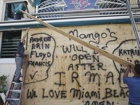 Workers shutter Mango's Tropical Cafe in Miami Beach, Fla., Thursday, Sept. 7, 2017.  The National Hurricane Center issued a hurricane watch for the Florida Keys and parts of South Florida, the first of perhaps many watches and warnings along the Southeastern coast over the next several days.
