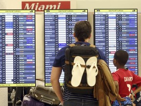 Passengers check the departure board at Miami International Airport Thursday, Sept. 7, 2017. South Florida officials are expanding evacuation orders as Hurricane Irma approaches, telling more than a half-million people to seek safety inland. (AP Photo/Marta Lavandier)