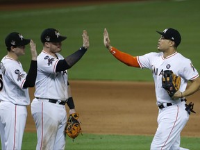 Miami Marlins' Giancarlo Stanton, right, Justin Bour, center, and Brian Anderson, left, celebrate after the Marlins defeated the Atlanta Braves 7-1 in a baseball game, Thursday, Sept. 28, 2017, in Miami. (AP Photo/Wilfredo Lee)