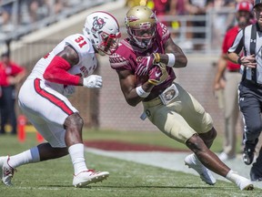 Florida State wide receiver Auden Tate closes his eyes before being hit by North Carolina State defender Jarius Morehead in the first half of an NCAA college football game in Tallahassee, Fla., Saturday, Sept. 23, 2017. (AP Photo/Mark Wallheiser)