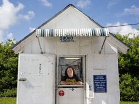 ADVANCE FOR THE WEEKEND OF SEPT. 23-24 AND THEREAFTER - In a June 2, 2016 photo, post office clerk Shannon Mitchell stands inside the Ochopee Post Office, known as the smallest in the United States, in Ochopee, Fla. The smallest post office in the United States survived one of the strongest hurricanes ever recorded. Mitchell, like many others in the area, lost her home to the ferocious Hurricane Irma. (Luke Franke/Naples Daily News via AP)