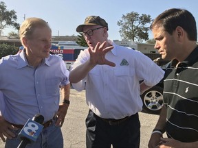 U.S. Sen. Bill Nelson, D-Fla., left,  talks with Michael Sparks, the CEO of Florida Citrus Mutual, an industry group, and U.S. Sen. Marco Rubio, R-Fla., Wednesday, Sept. 13, 2017, in Lake Wales, Fla. The senators toured an orange grove in Lake Wales to assess the scope of damage to the state's iconic crop in the wake of Hurricane Irma. (AP Photo/Tamara Lush)